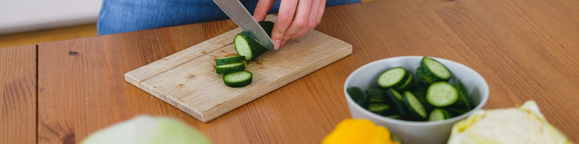 vrouw snijdt komkommer als illustratie bij een blog over korten of boete op je pensioen