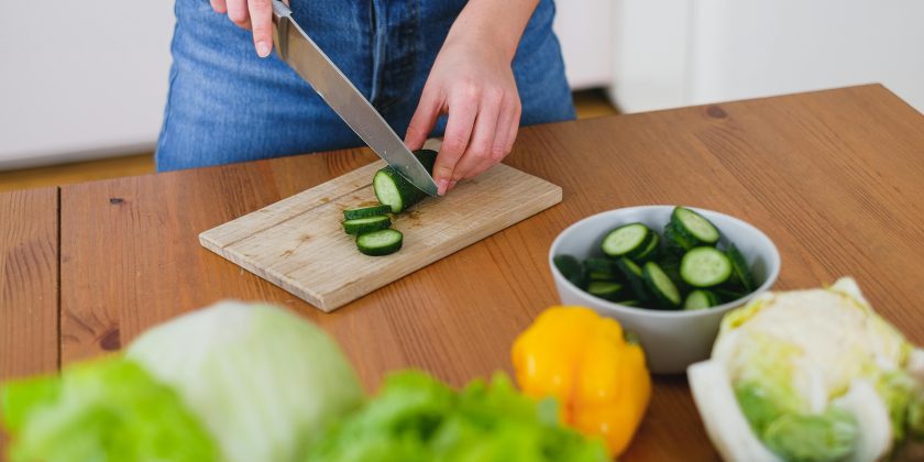 vrouw snijdt komkommer als illustratie bij een blog over korten of boete op je pensioen