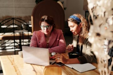 twee vrouwen zitten achter een computer als afbeelding bij een blog over pensioenoverzicht