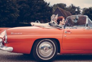 Paar dat in rode Ford Thunderbird rijdt, illustratie bij blog over AOW-overbruggingspensioen