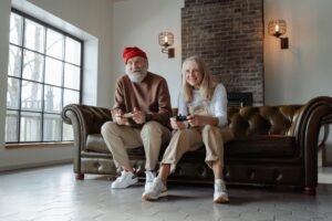 Twee oudere mensen gamen op de bank als illustratie bij blog over wanneer verandert jouw pensioen