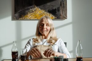 Vrouw aan tafel met drinken en fiches als illustratie bij pensioen en RVU