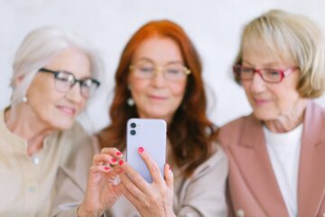 3 vrouwen op een telefoon als afbeelding bij artikel over pensioenplanning maken