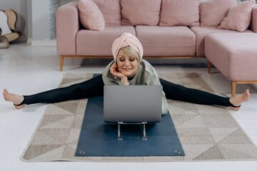 oudere vrouw doet yoga achter computer als afbeelding bij blog over gezond oud worden