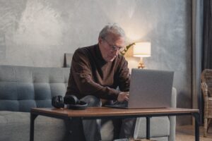 Oudere man achter computer bij AOW-bedragen 2023