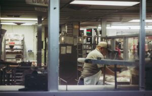man werkt in bakkerij met deeg op een tafel, afbeelding bij blog over pensioen uitkeren terwijl je werkt