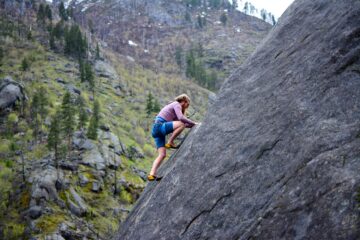 man klimt tegen een rots op als afbeelding bij een blog over beleggingsrisico eerder met pensioen