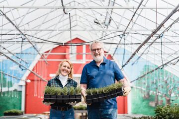 man en vrouw in een tuin met een bak planten, als afbeelding bij een artikel over partnerpensioen jongere partner