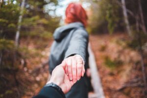 man en vrouw lopen in een bos en houden elkaars hand vast als afbeelding bij een pagina over pensioen inzicht coaching