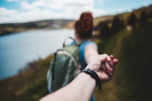 man en vrouw houden hand vast tijdens een hike, als afbeelding bij een blog over vervroegd pensioen en scheiding