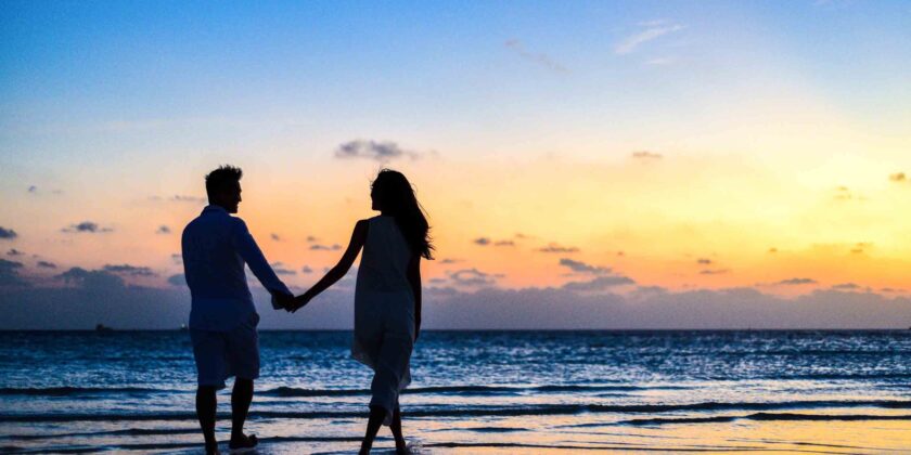 man en vrouw op het strand bij zonsondergang als afbeelding bij een blog over maximaal partnerpensioen
