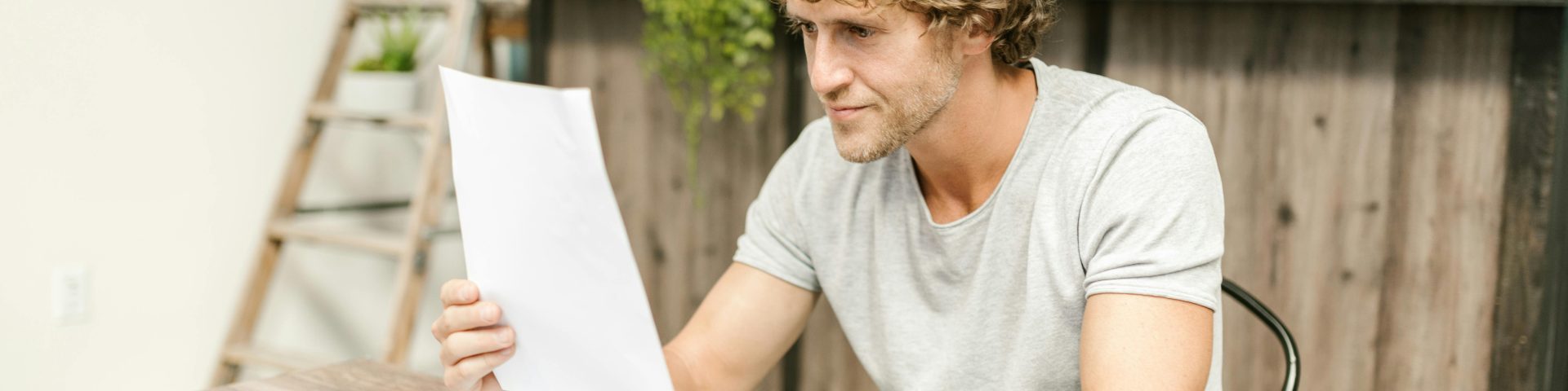 Man zit aan tafel en leest een papier, dit zou een transitieplan kunnen zijn in verband met eerder met pensioen en invaren