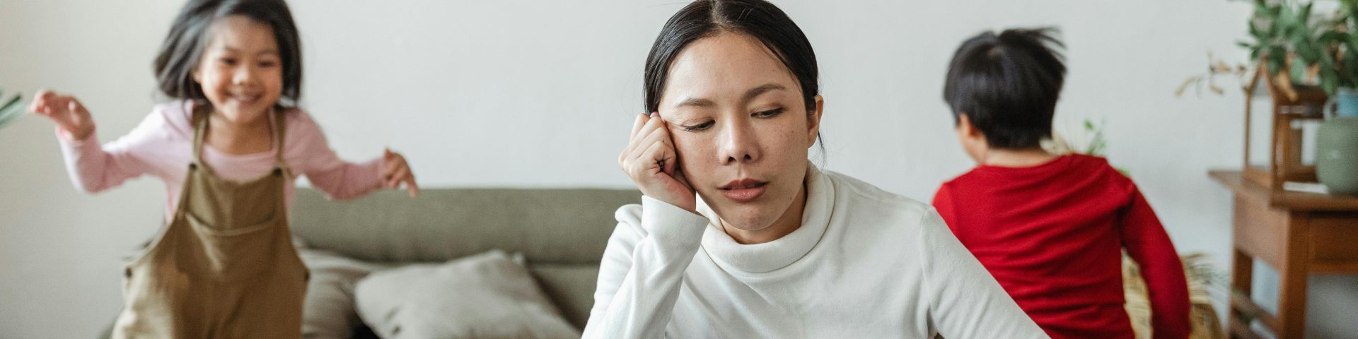 Vrouw werkt thuis met kinderen op de achtergrond als illustratie van een zwaar beroep bij RVU-regeling verlengen