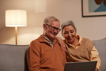 man en vrouw zitten op de bank en kijken naar een computer over AOW 2025