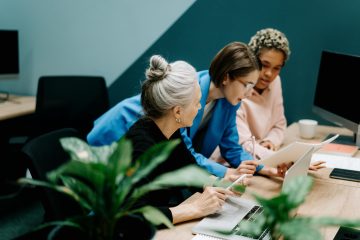 3 vrouwen achter een computer als afbeelding bij een blog over AOW-bedragen per 1 juli 2025