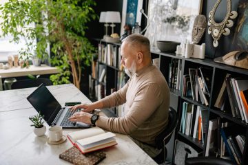 man achter een computer als afbeelding bij een blog over besparen en eerder met pensioen