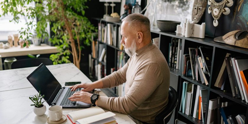 man achter een computer als afbeelding bij een blog over besparen en eerder met pensioen