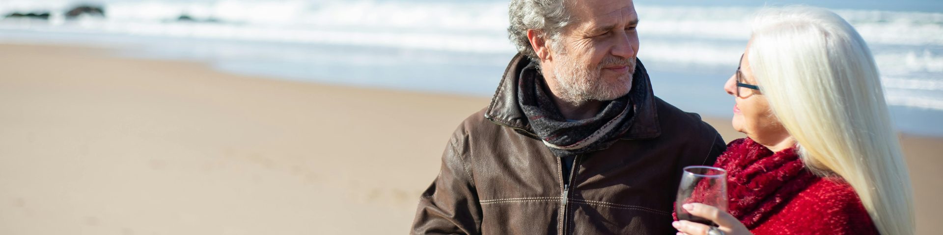 Twee mensen proosten op het strand als illustratie bij een blog over eerder met pensioen en compensatie