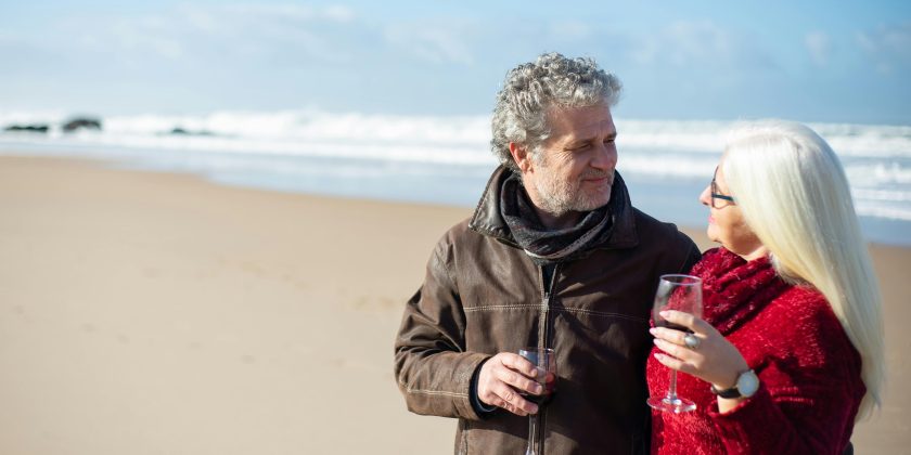 Twee mensen proosten op het strand als illustratie bij een blog over eerder met pensioen en compensatie
