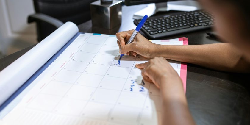 iemand schrijft op een kalender als illustratie bij een blog over de AOW-leeftijd op basis van de kabinetsplannen